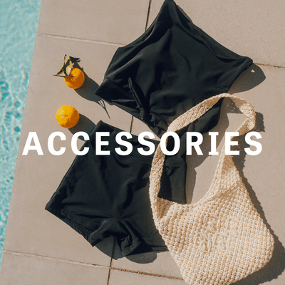 Photo of black cropped swim top and black high waist boy shorts laying out by pool with oranges and knit swim bag