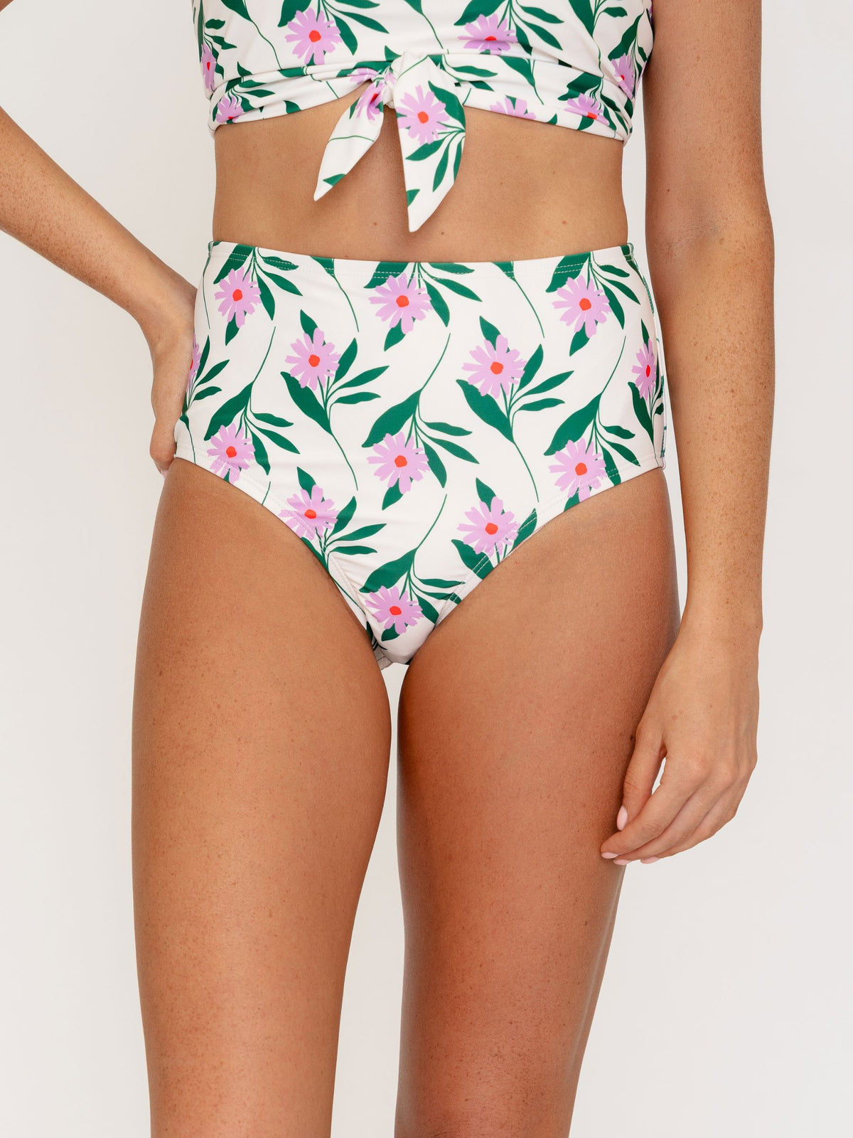 Woman wearing a tropical leaf patterned bikini set on a white background