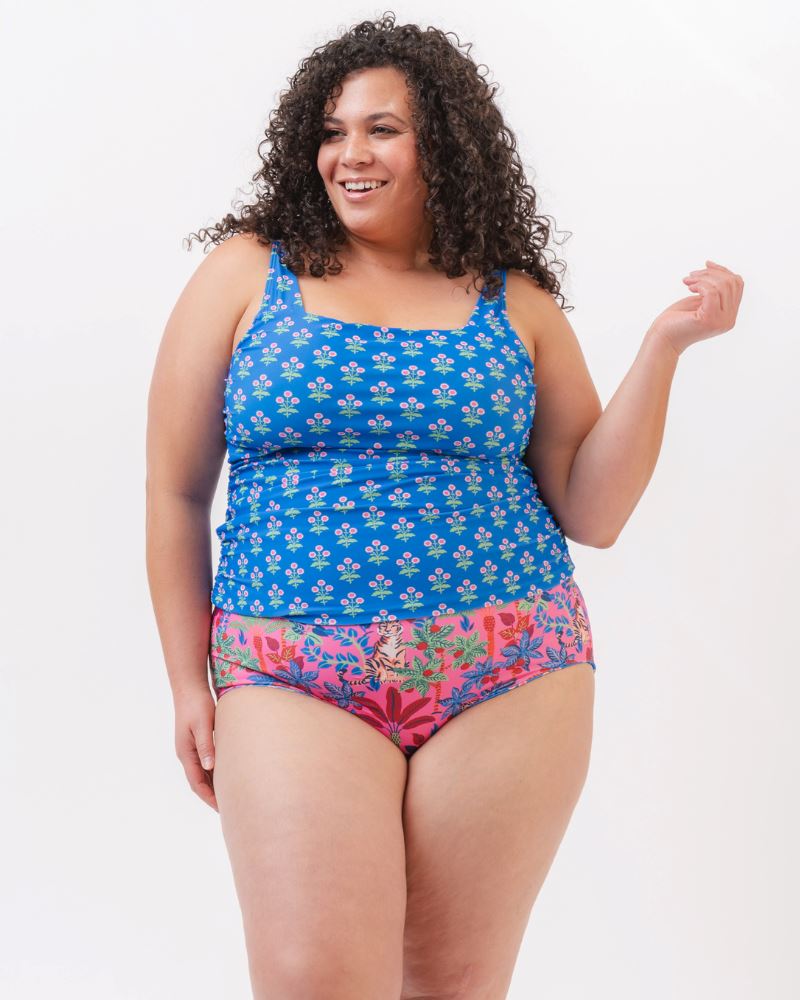 Photo of a woman wearing a blue floral print square neck swim tankini with a bold pink tiger print high waist swim bottom