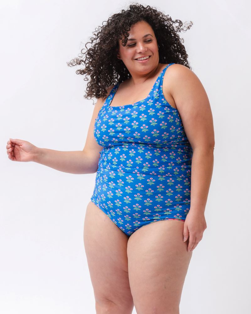 Photo of a woman wearing a blue floral print square neck swim tankini with a blue floral print high waist swim bottom