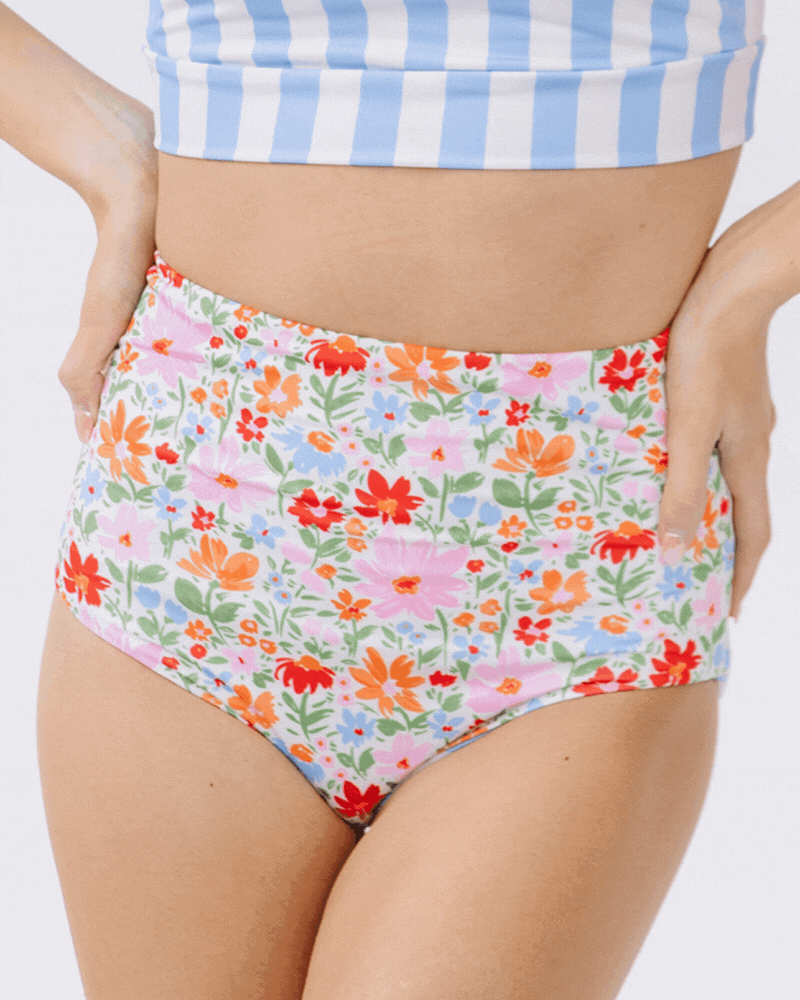 GIF of a woman wearing peri stripe/ multi color floral reversible swim bottom