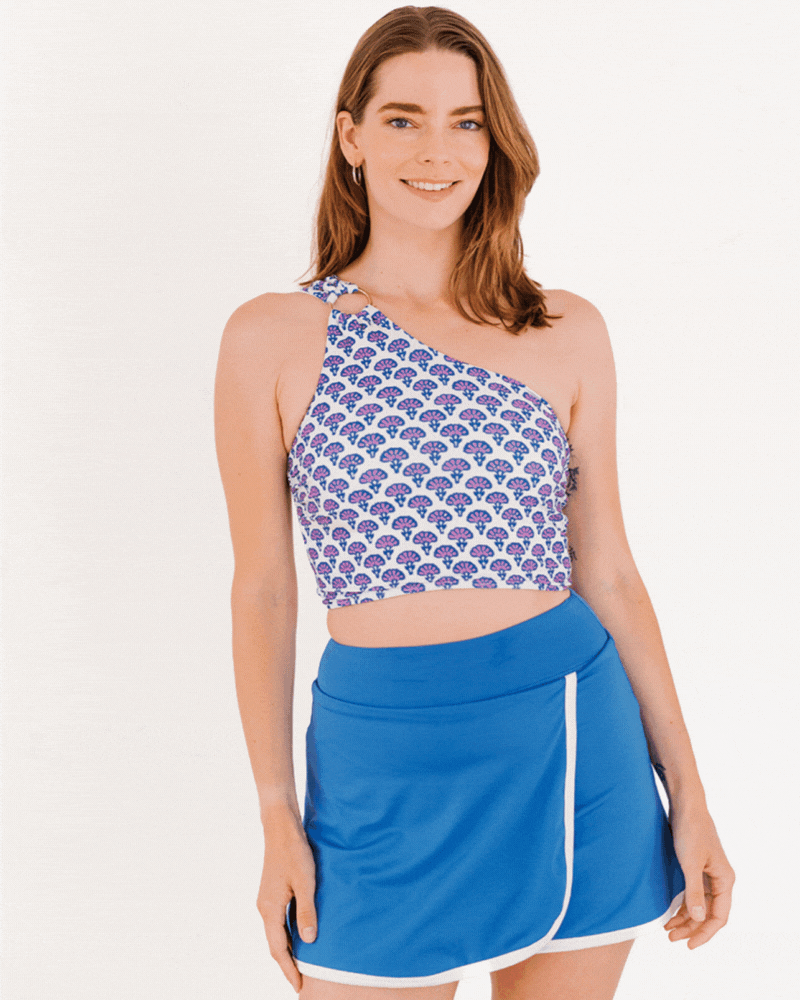 GIF of a woman wearing a Block Floral One-shoulder swim crop top and a Capri swim skirt bottom