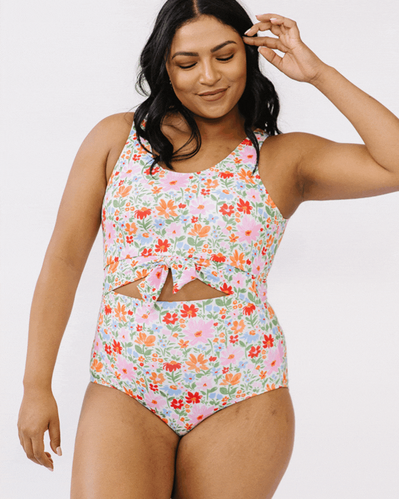 GIF of a woman wearing a floral knotted swim one piece