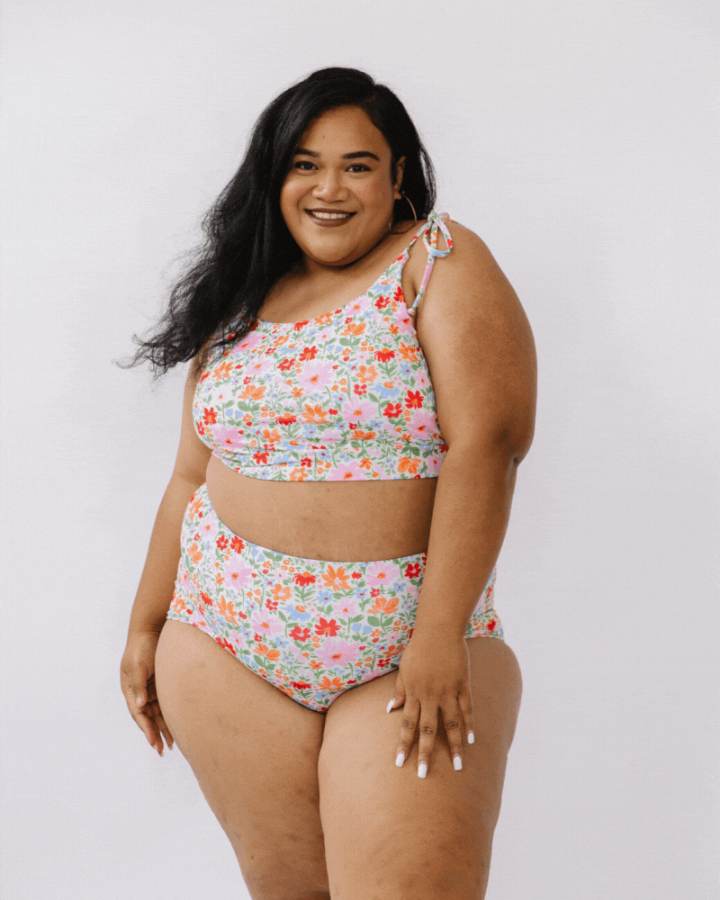 GIF of a woman wearing a floral shoulder-tie swim crop top and a floral swim bottom