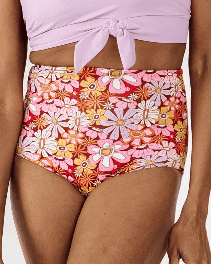 GIF of a woman wearing a Groovy Blooms/sherbet stripe reversible swim bottom and a Lilac swim crop top