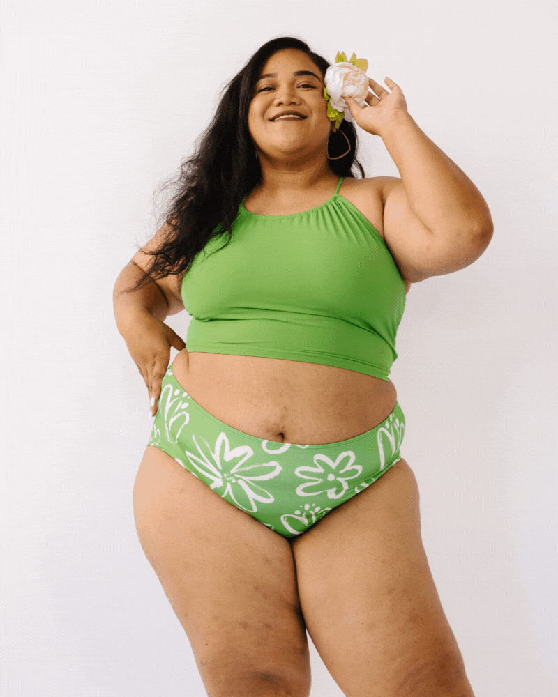 GIF of woman wearing green cropped lace back swim top with green and white floral swim bottoms