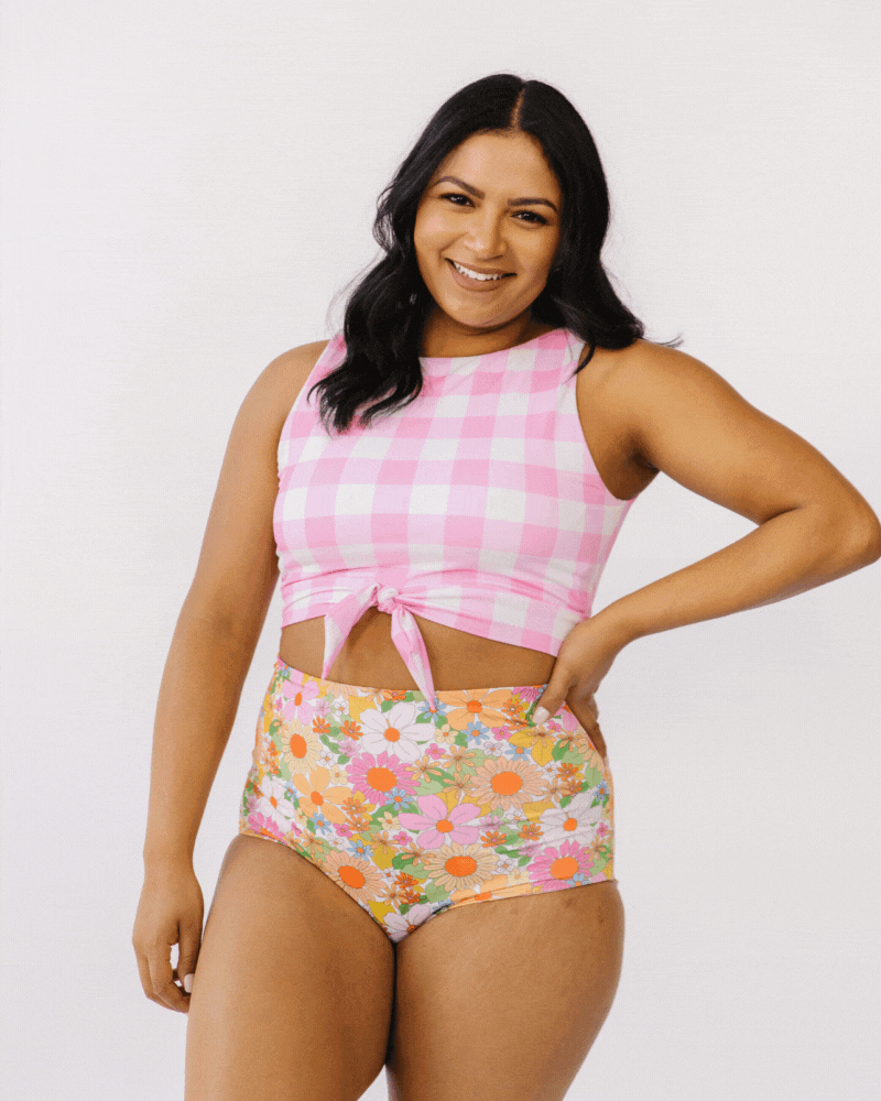 GIF of woman wearing pink gingham cropped swim top with multi colored floral swim bottoms