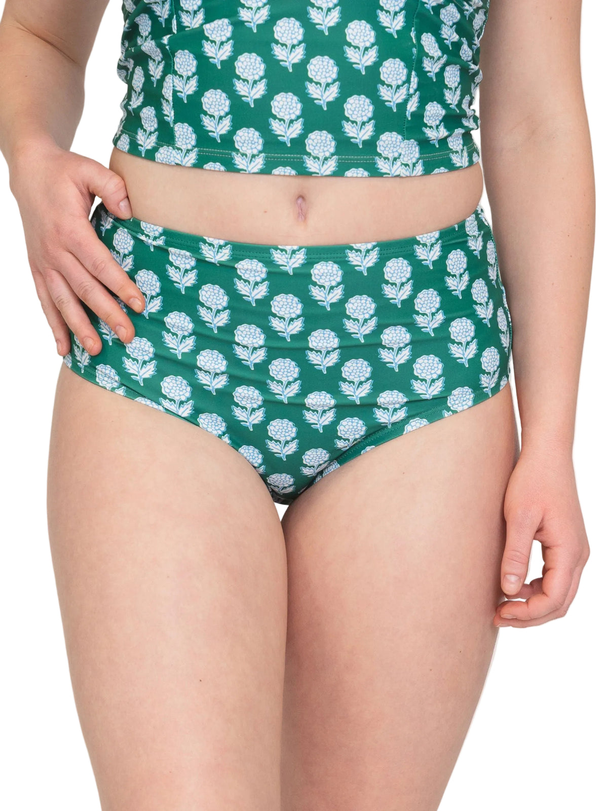Woman in a Green bikini and matching Top with white floral pattern on a white background