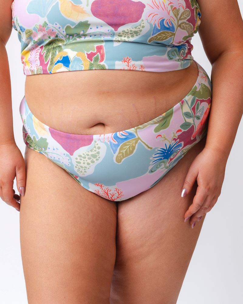 Close up photo of a woman wearing a colorful seashell inspired high waist swim bottom