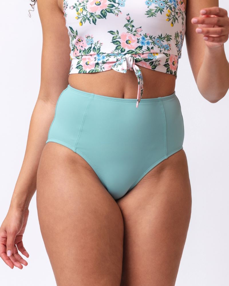 Close up photo of a woman wearing a light blue high waist swim bottom