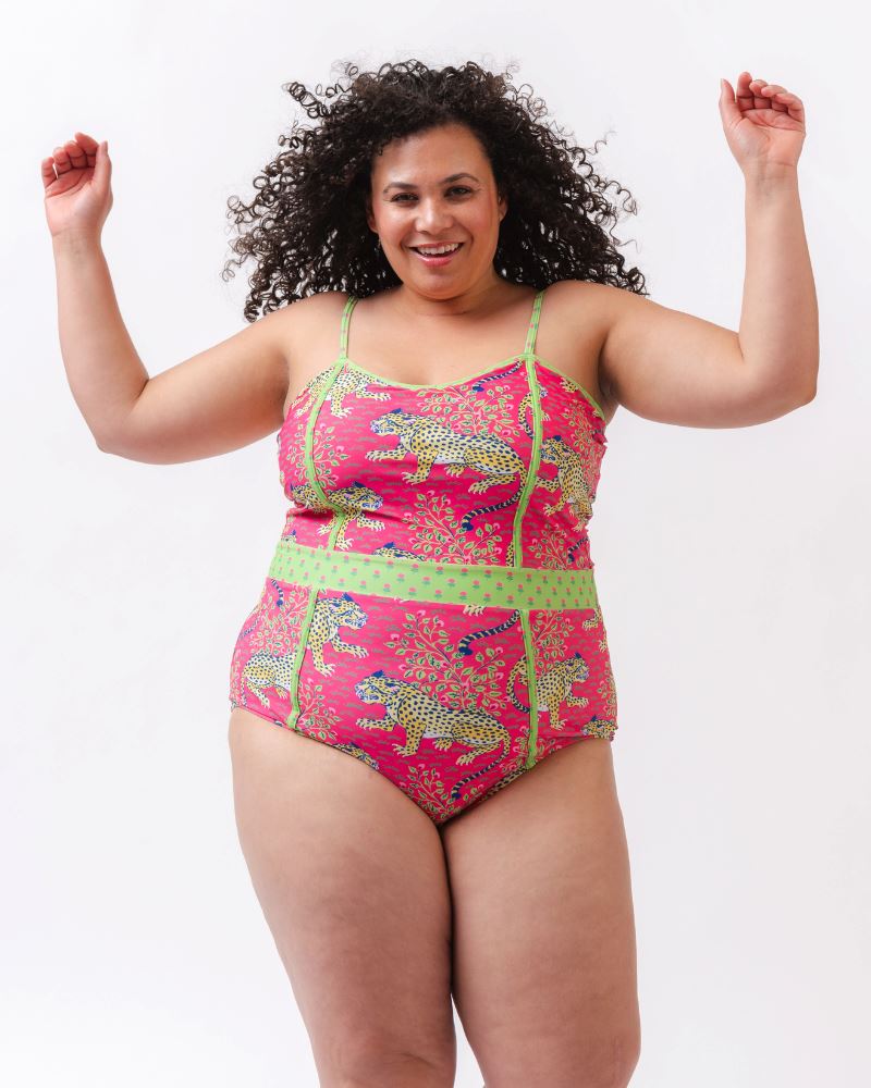 Photo of a woman wearing a bold pink and green print featuring tigers classic one-piece swim suit
