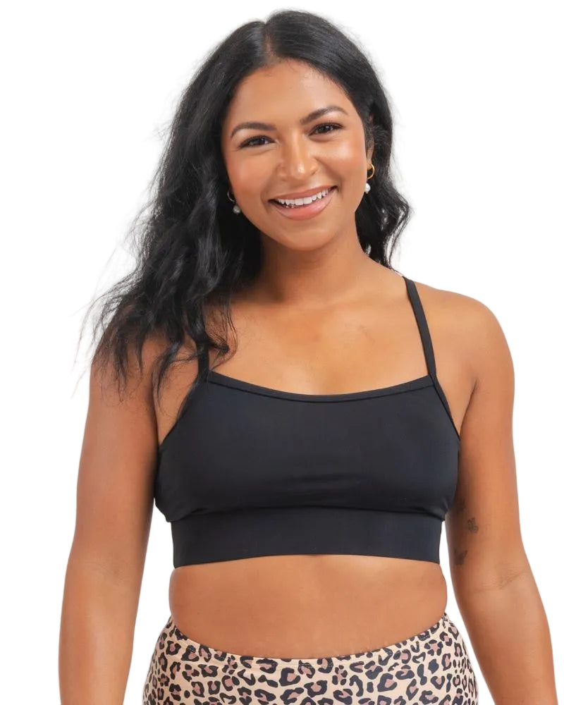 close up of a Woman wearing a black sports bra and leopard print bikini bottoms on a white background