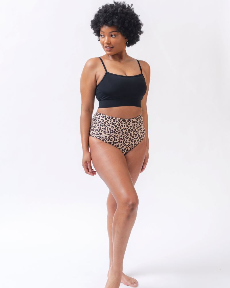 Photo of a woman wearing a black swim bralette and a leopard print high waist swim bottom