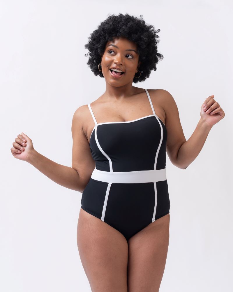 Photo of woman wearing a black and white classic one piece swim suit
