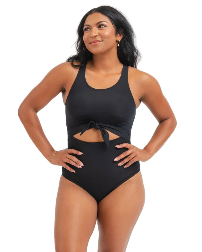 Woman wearing a black knotted one piece swimsuit with a white background
