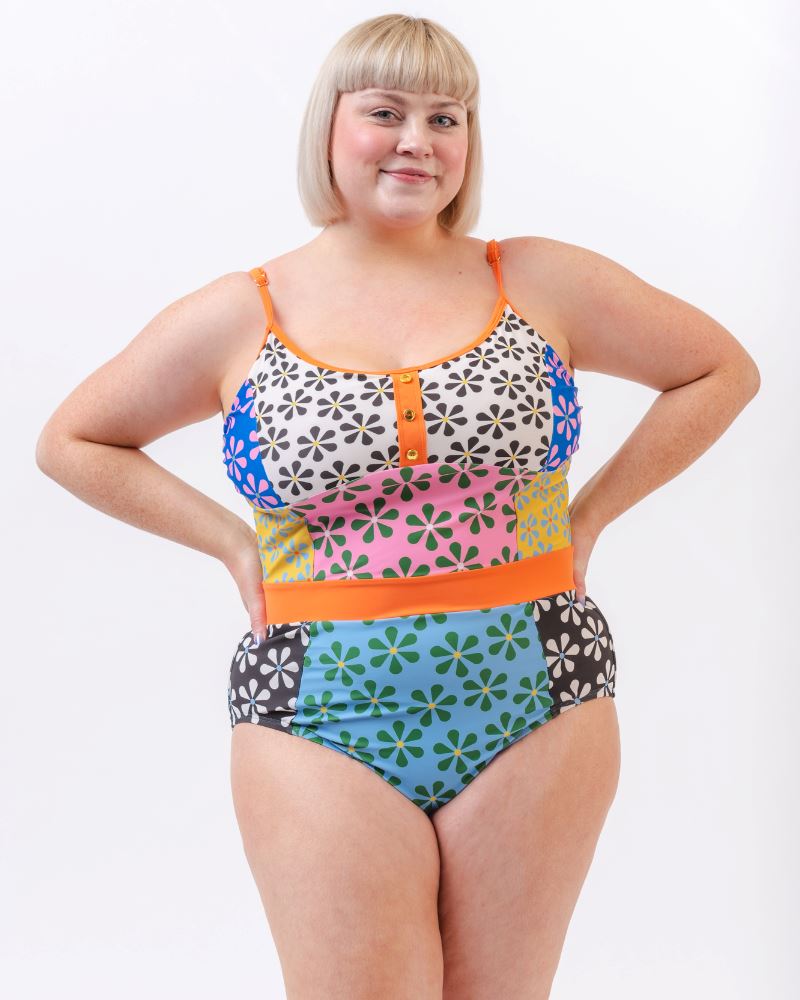 Photo of a woman wearing a multi-colored floral one-piece swimsuit