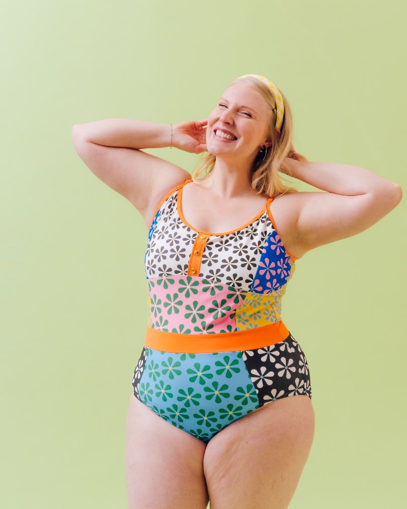Photo of a woman wearing a multi-colored floral one-piece swimsuit