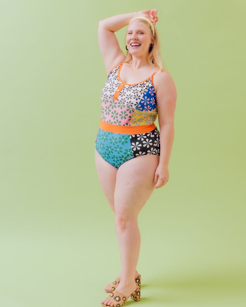 Photo of a woman wearing a multi-colored floral one-piece swimsuit