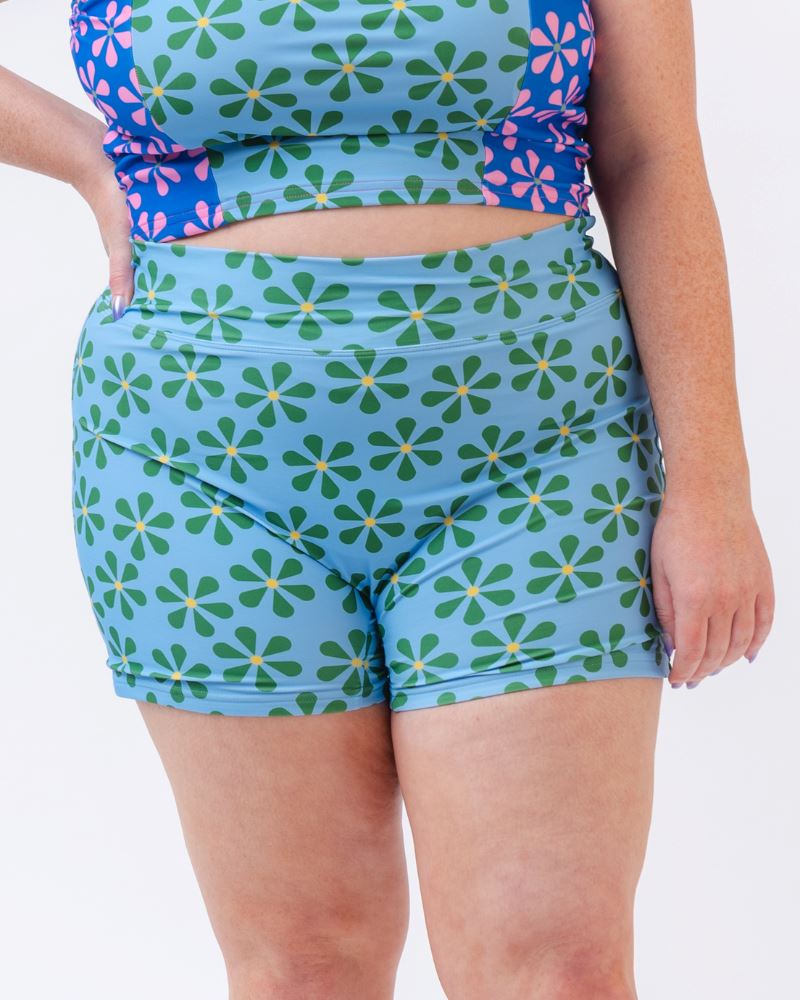 Close-up photo of a woman wearing a blue and green floral swim short bottom