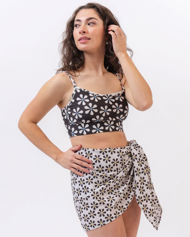 Photo of a woman wearing a black and white floral sarong and a black and white floral swim bralette