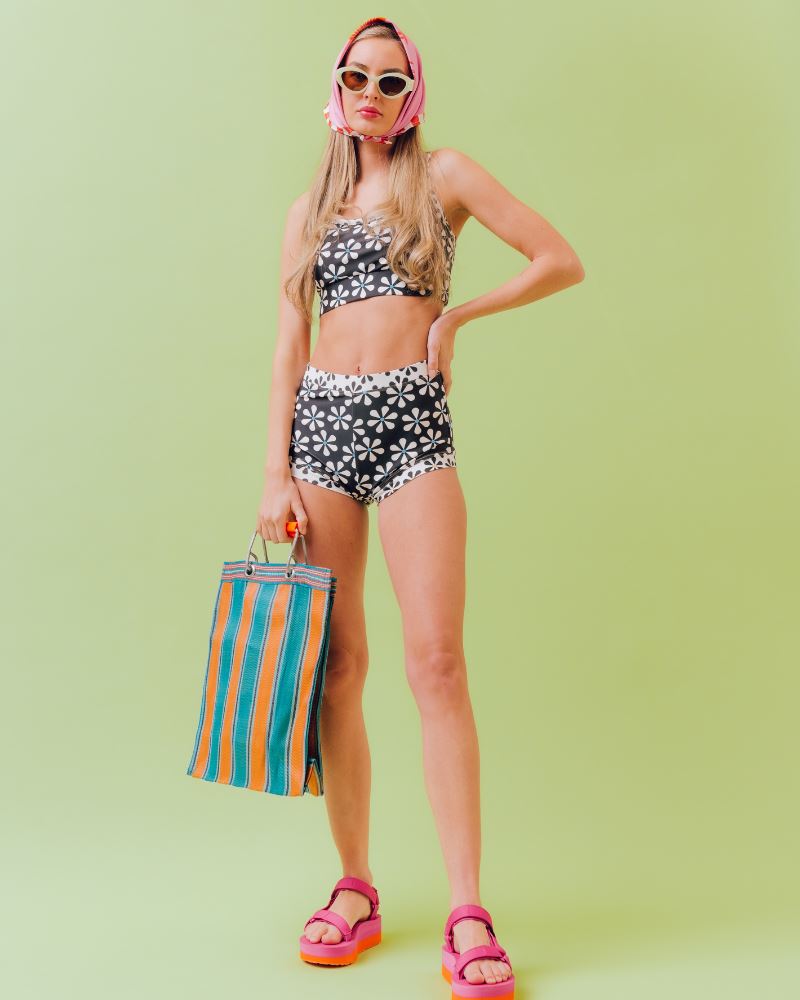 Photo of a woman wearing a black and white floral swim bralette and a black and white floral swim short bottom