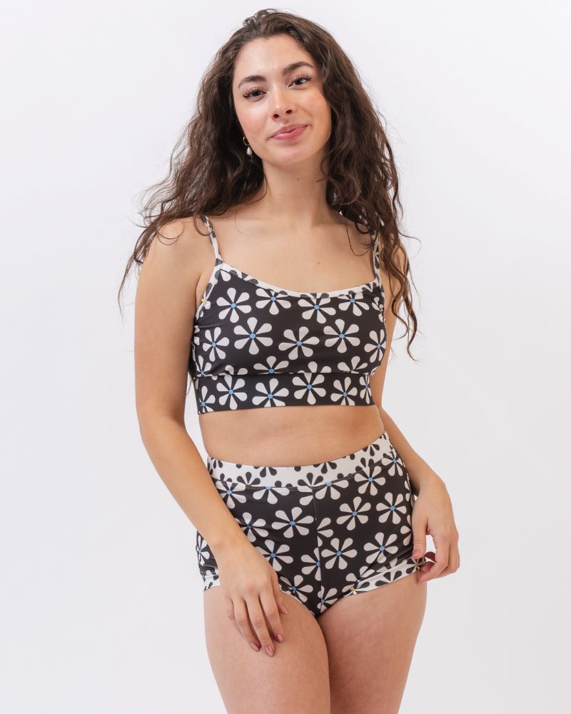 Photo of a woman wearing a black and white floral swim bralette and a black and white floral swim short bottom