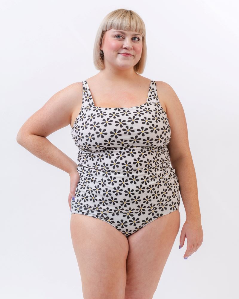 Photo of a woman wearing a black and white floral square neck swim top and a black and white floral swim bottom