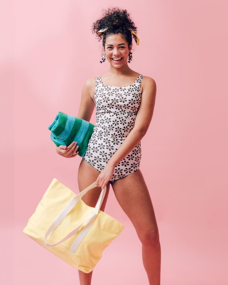 Photo of a woman wearing a black and white floral square neck swim top and a black and white floral swim bottom