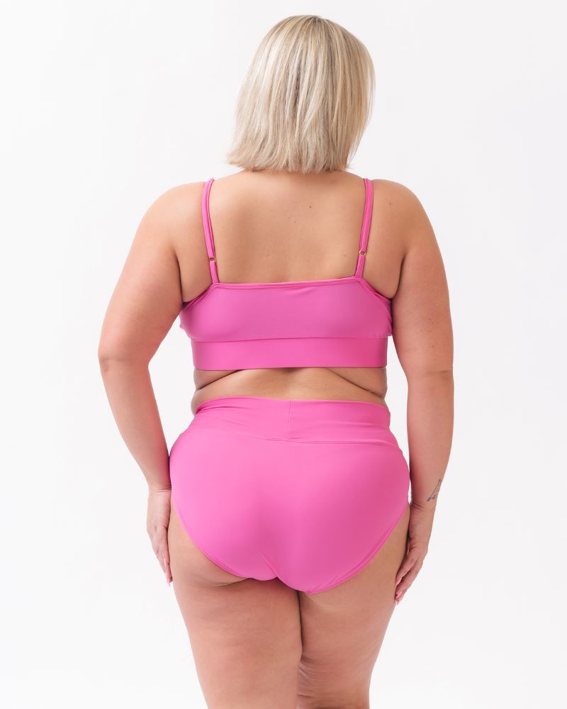 Photo of a woman wearing a dark pink swim top and a dark pink classic swim bottom -back angle