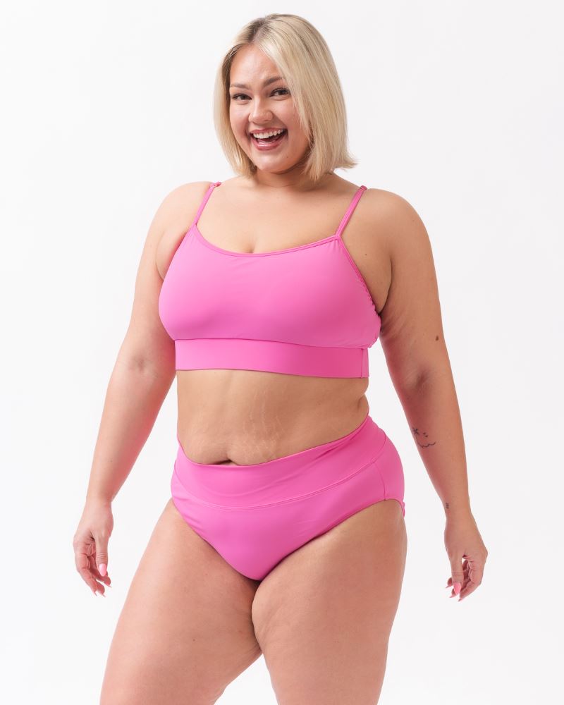Photo of a woman wearing a dark pink swim bralette and a dark pink swim bottom