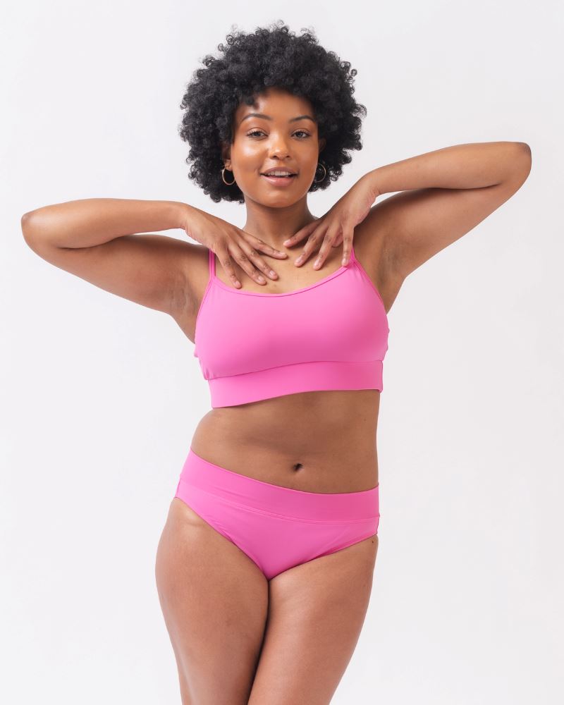 Photo of a woman wearing a dark pink swim top and dark pink classic swim bottoms
