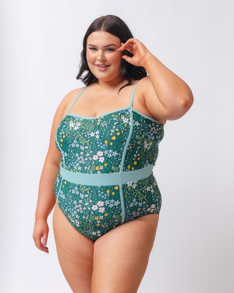 Photo of a woman wearing a dark green floral classic one-piece swimsuit