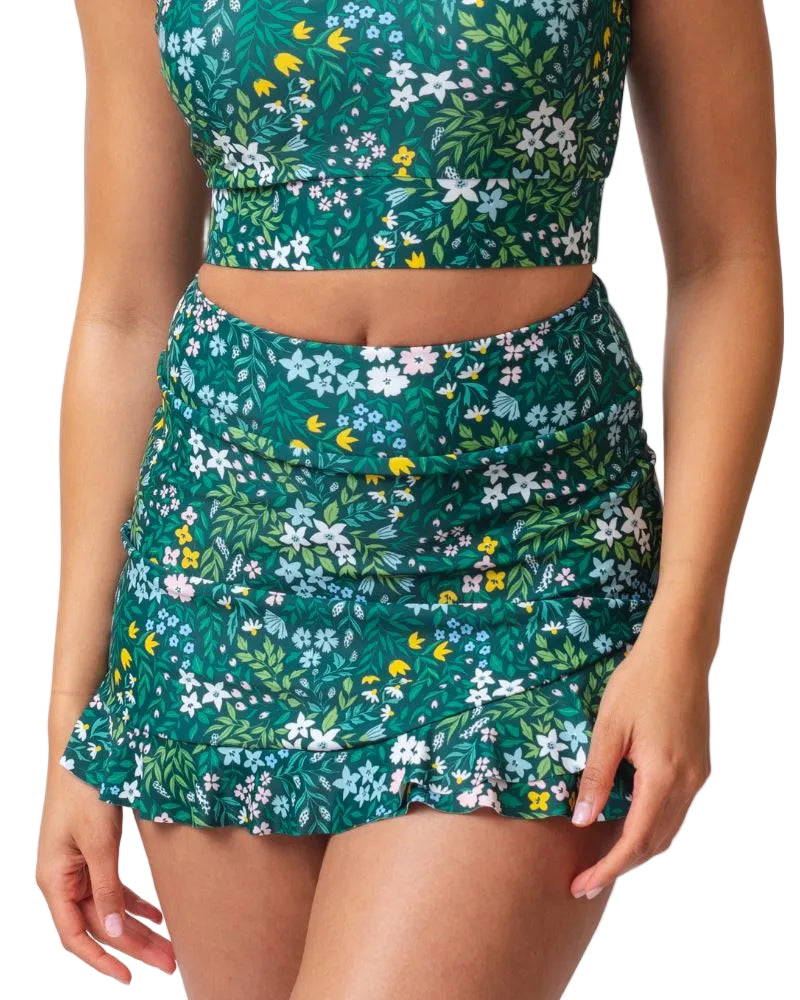 Close up photo of a woman wearing a dark green floral swim skirt
