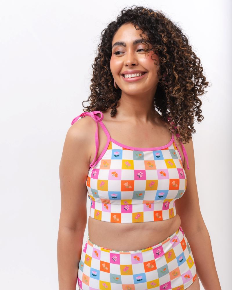 Close up photo of a woman wearing a multi colored checkered print cropped swim top with multi colored checkered print high waist swim bottoms