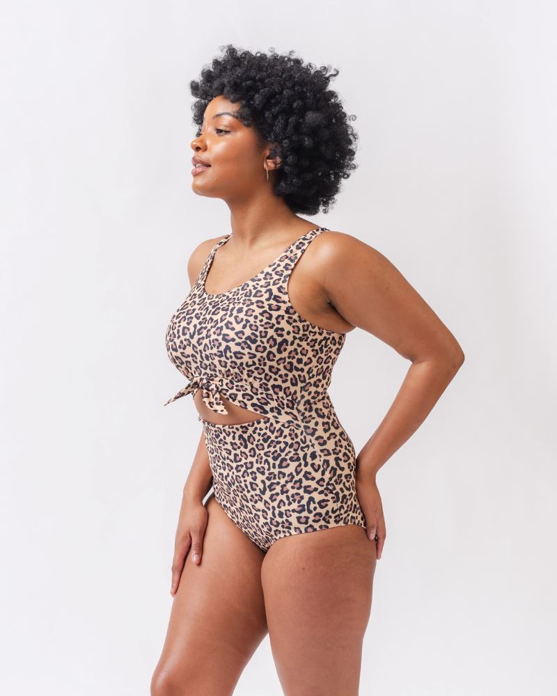 Photo of a woman from the side wearing a leopard print one piece swimsuit