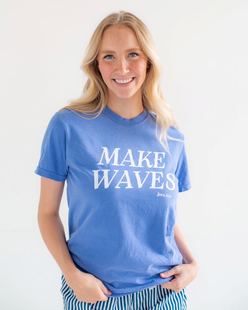 Photo of woman wearing blue Lime Ricki Make Waves t-shirt with blue and white striped swim shorts
