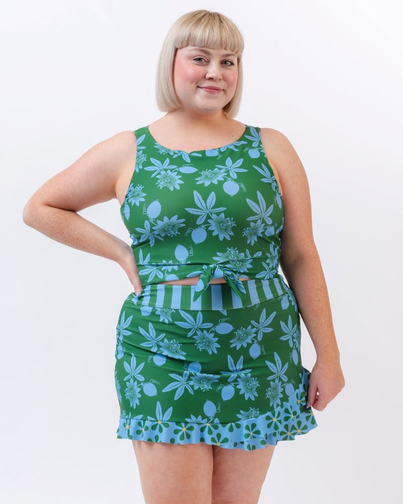 Photo of a woman wearing a green and blue floral swim crop top and a green and blue floral swim skirt bottom
