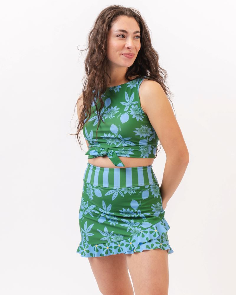 Photo of a woman wearing a green and blue floral swim skirt and a green and blue floral swim crop top