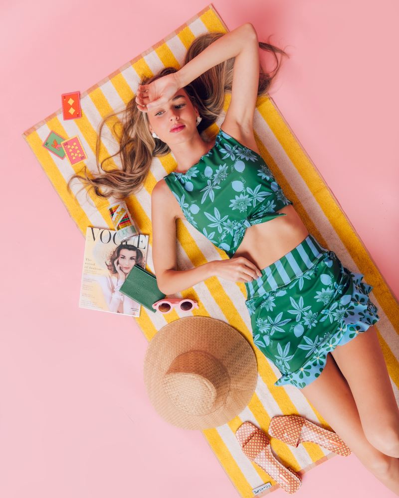 Photo of a woman wearing a green and blue floral swim skirt and a green and blue floral swim crop top