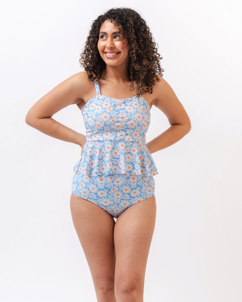Photo of a woman wearing a blue floral tankini swim top with blue floral high waist swim bottoms