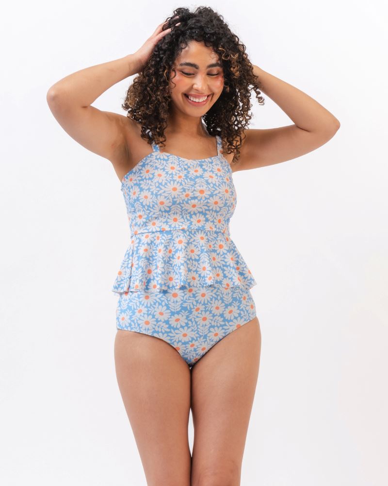 Photo of a woman wearing a blue floral tankini swim top with blue floral high waist swim bottoms