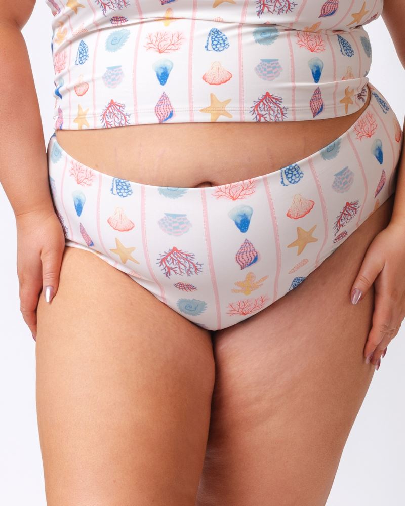 Close up photo of a woman wearing a seashell striped high waist swim bottom