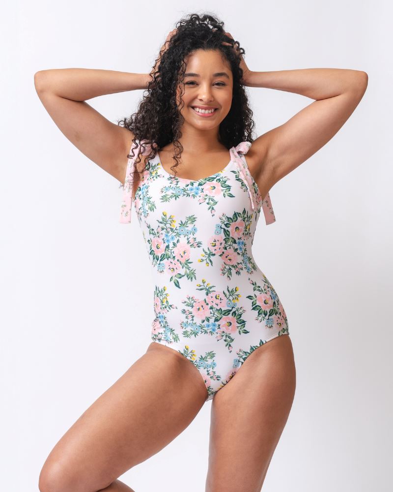 Photo of a woman wearing a pink and white floral one piece swimsuit