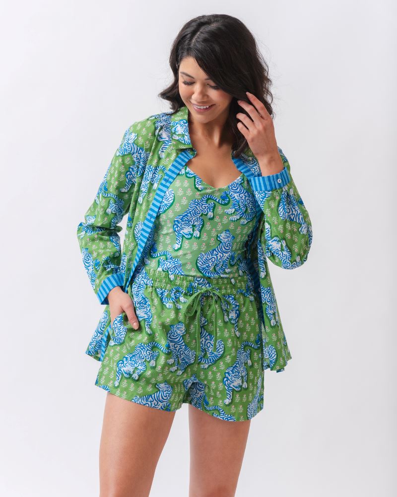 Photo of a woman wearing a bold green and pink tiger print shoulder tie swim one piece with a bold green tiger print cover up set