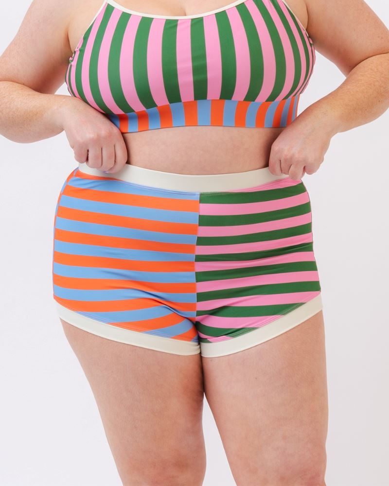 Close-up photo of a woman wearing a multi-colored striped retro swim short bottom