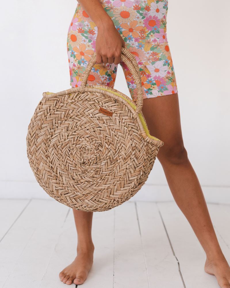 Photo of woman holding a round beach bag