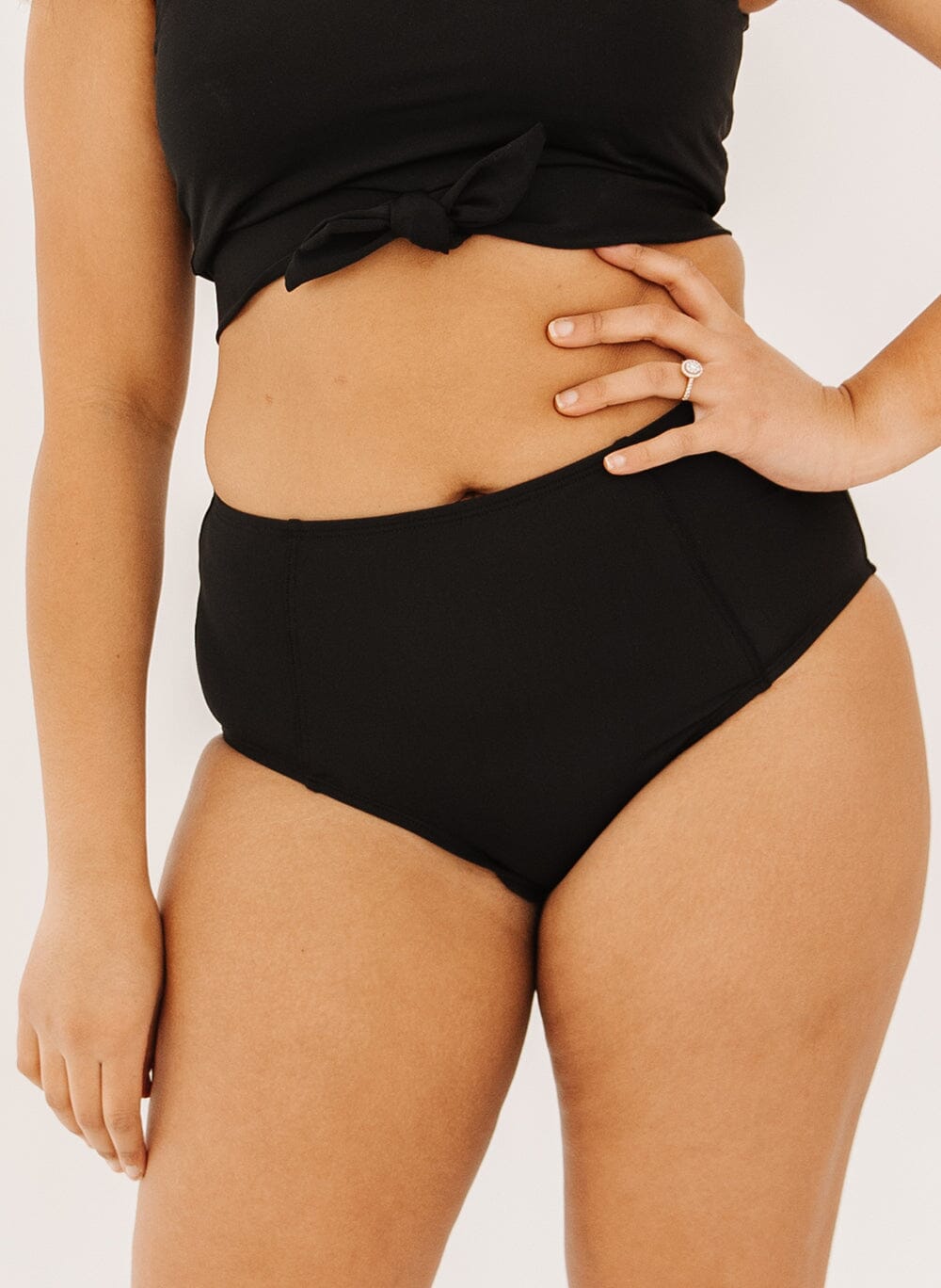 Photo of a woman wearing black high-waist swim bottoms