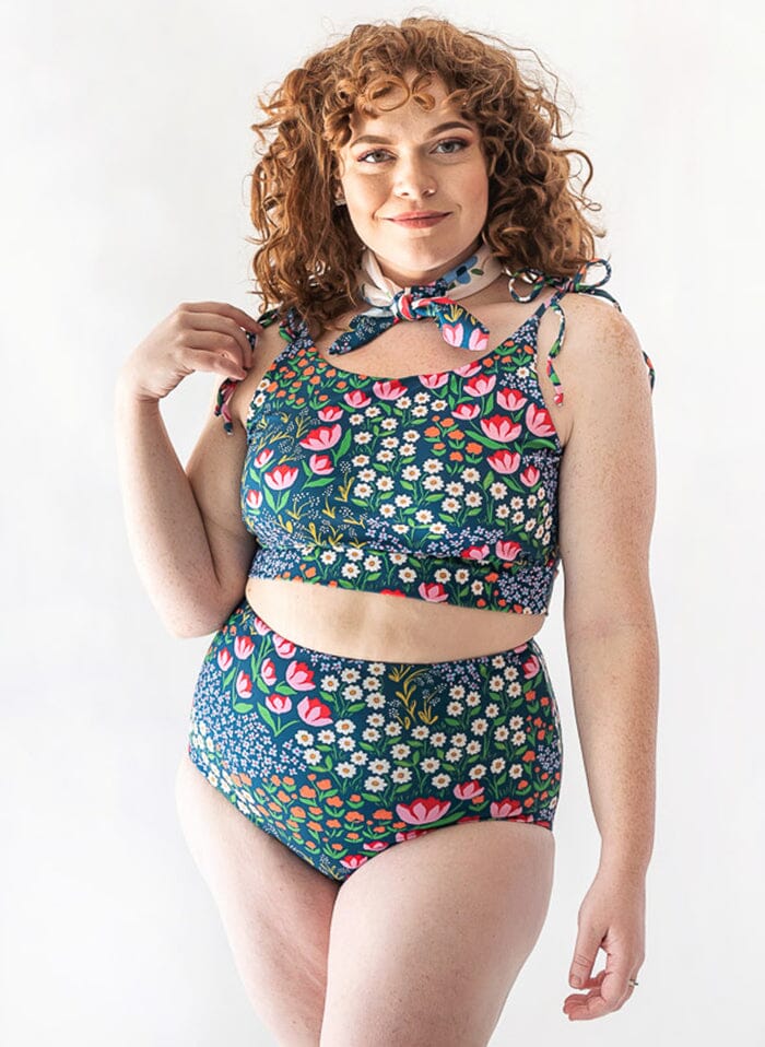 of a woman wearing a Blixen/Indigo reversible swim bottom floral side and a Blixen shoulder-tie swim crop top