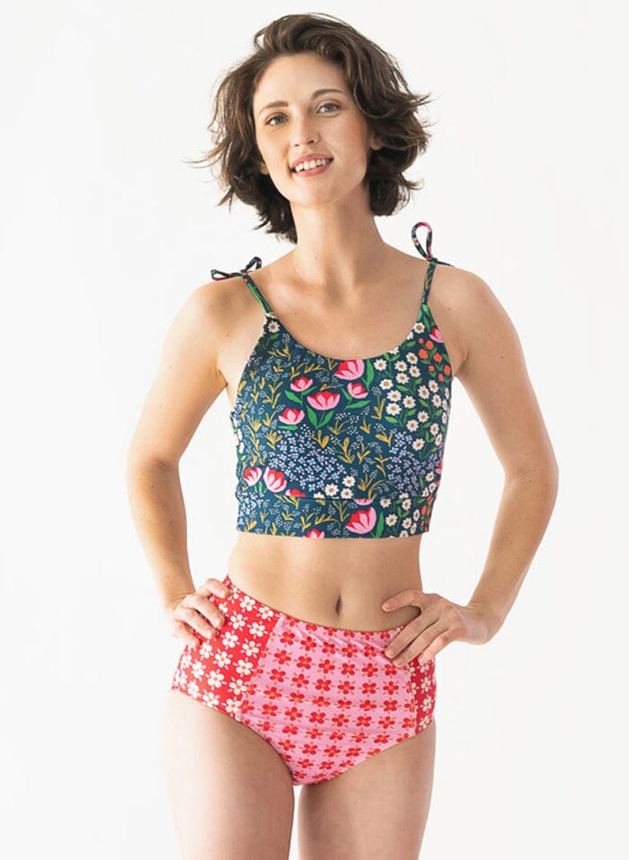 Photo of a woman wearing a Blixen shoulder-tie swim crop top and a floral swim bottom