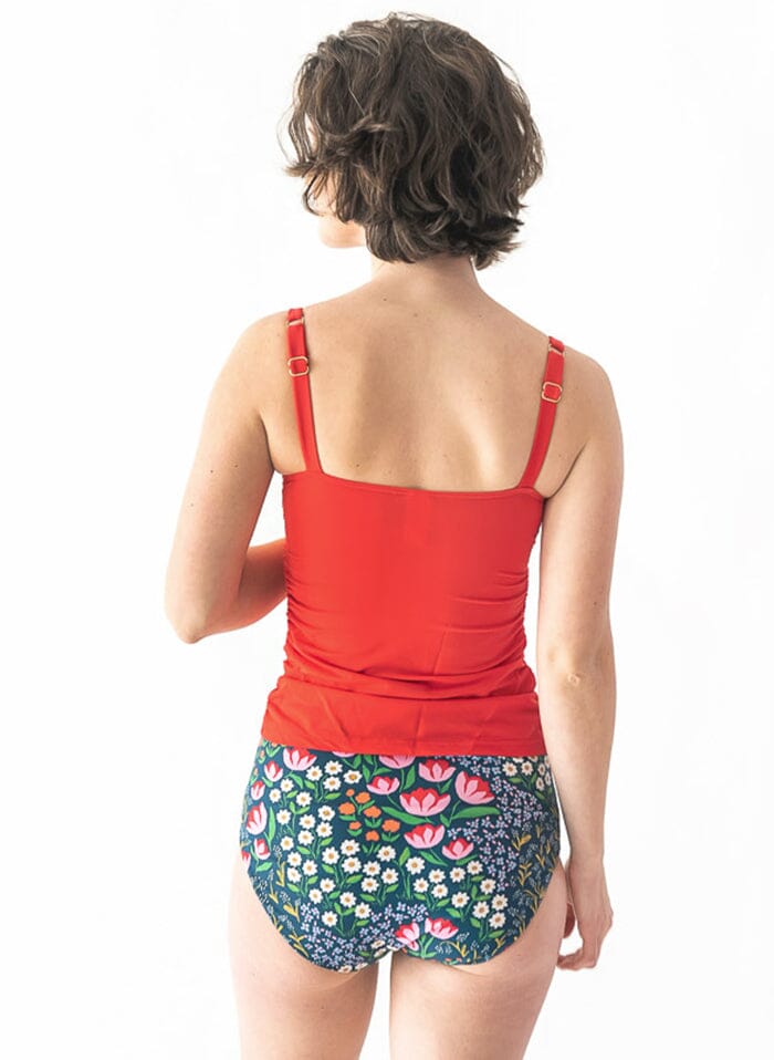 Photo of a woman wearing a red square-neck swim top and a Blixen swim bottom back angle